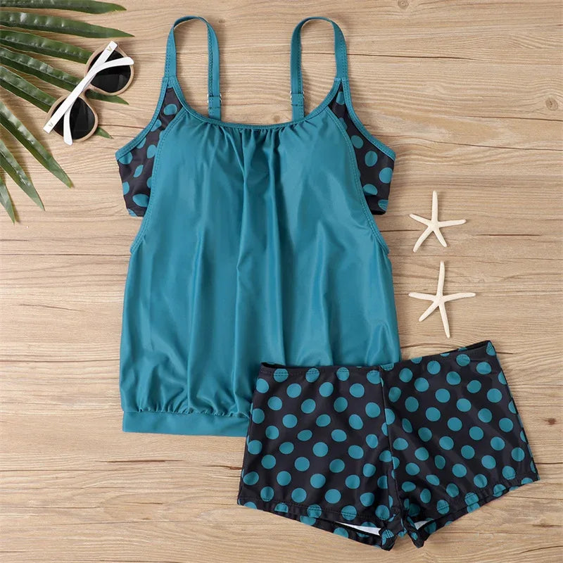 Flat lay: turquoise tankini top and black polka-dot boxer shorts set