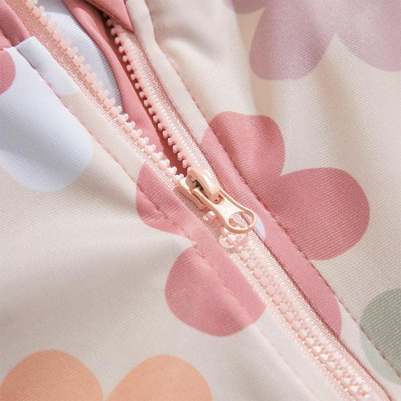 Toddler floral tropical long sleeve swimsuit with sun hat in pastel cream with pink and light blue floral pattern