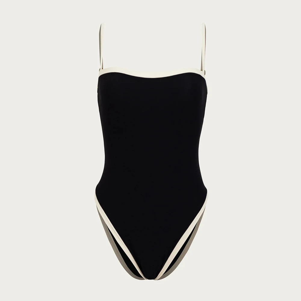 Black square neck one piece swimsuit with white trim and thin straps laid flat on white