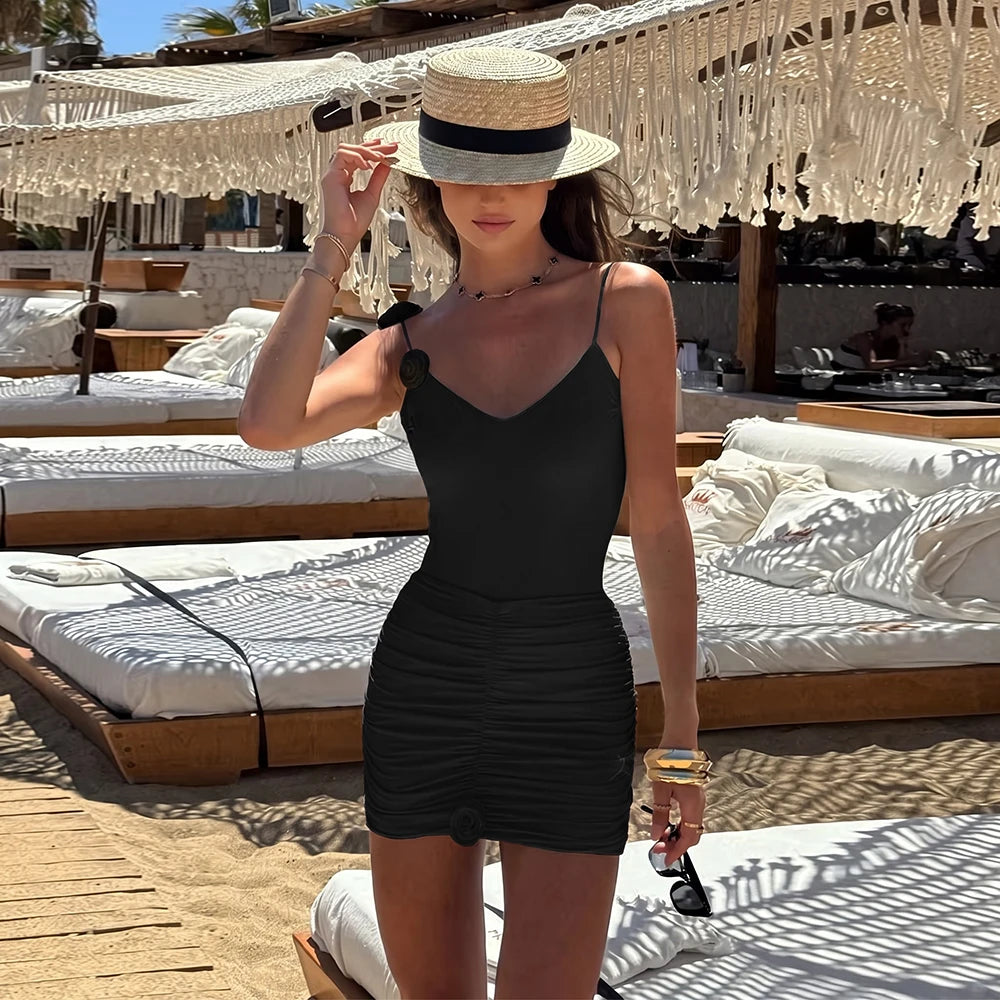 woman in black ruched mini dress one piece swimsuit on the beach