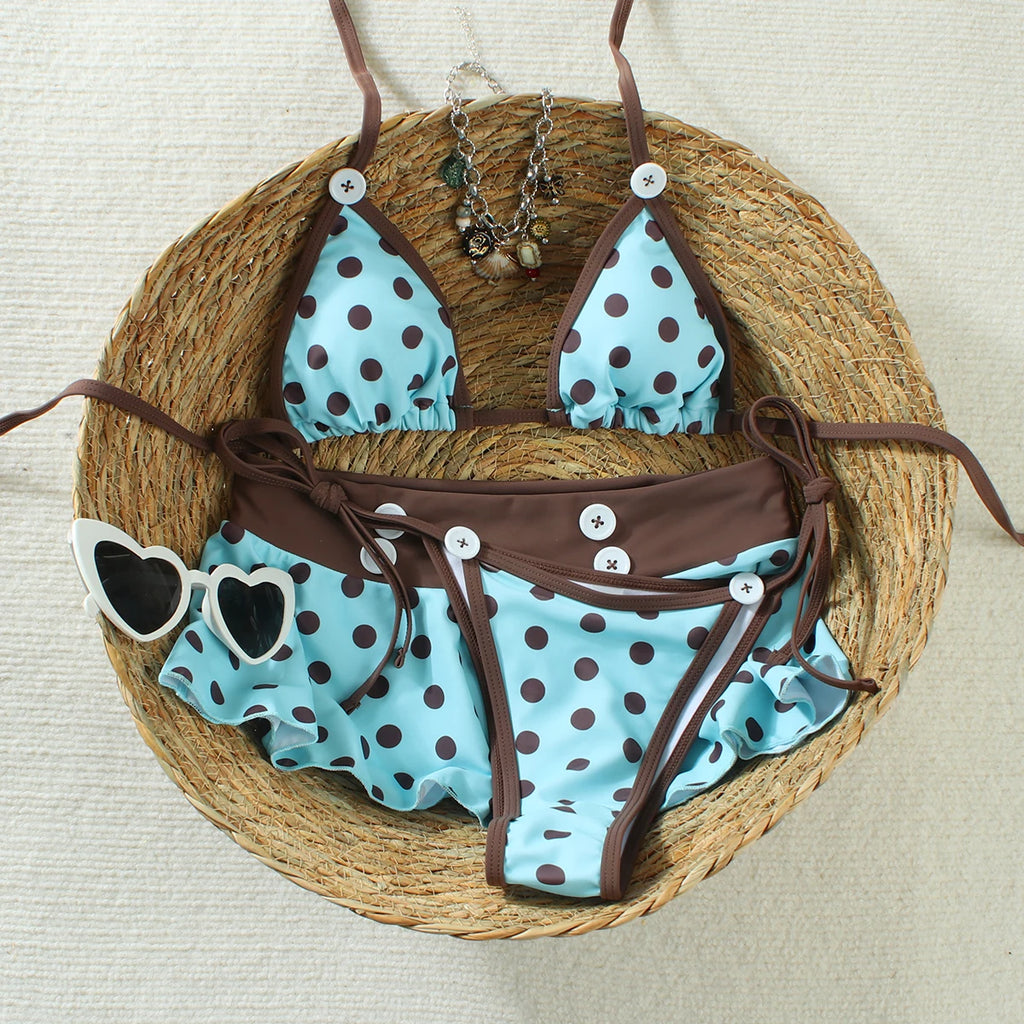 cyan polka dot bikini set with brown trim laid flat on a woven basket