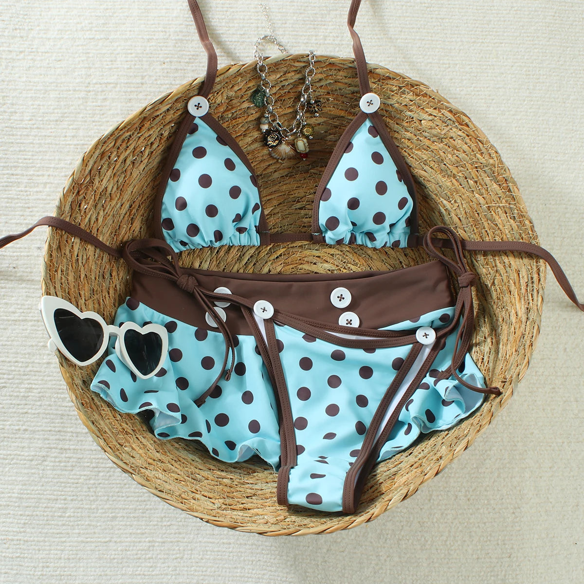 cyan polka dot bikini set with brown trim laid flat on a woven basket
