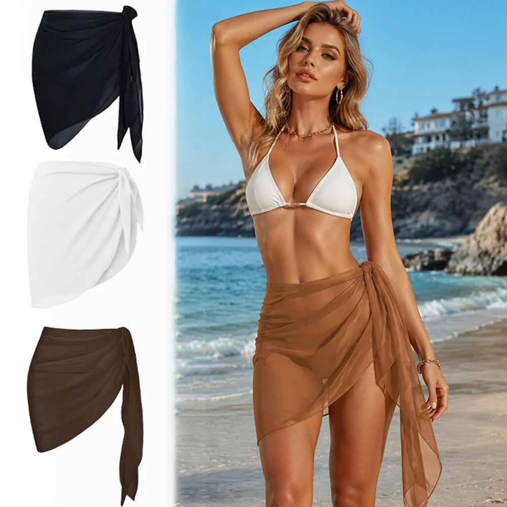 three chiffon beach sarongs in black white and caramel with a model wearing the caramel wrap on the beach