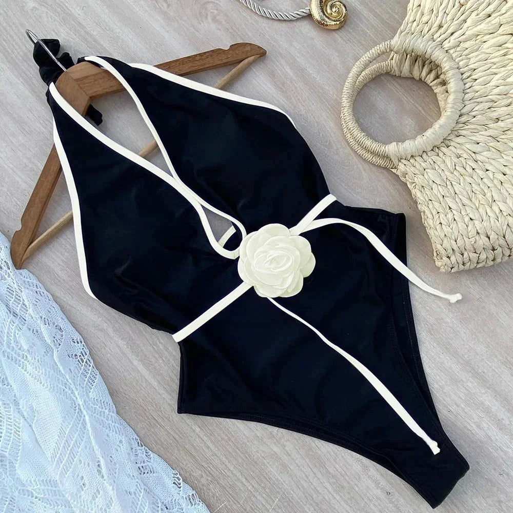 black halter bikini top and tie waist bottoms laid flat with ivory trim