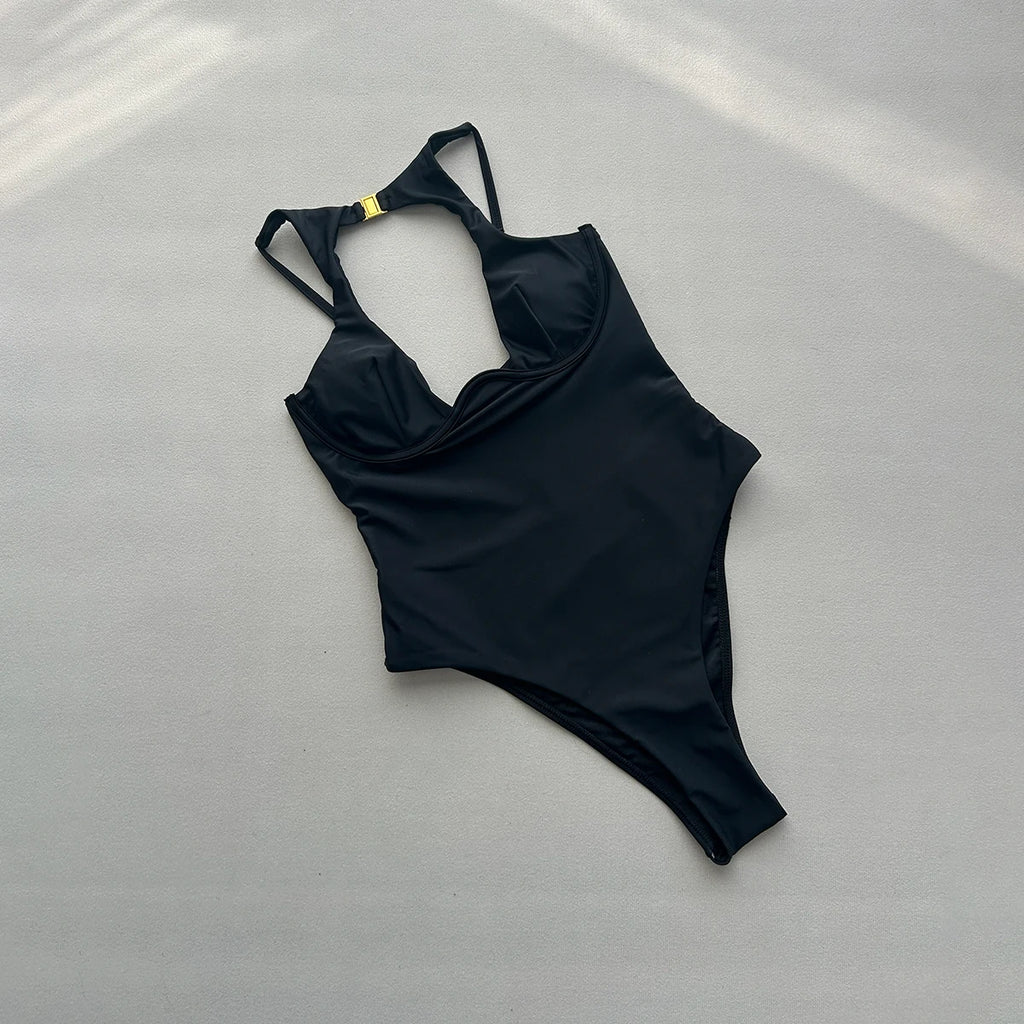 Back of black one piece swimsuit showing halter straps with gold rings and clasp