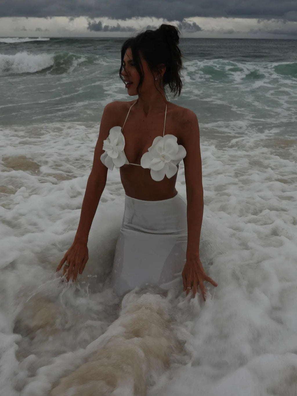Model in the white floral applique bikini top and matching white maxi skirt on the beach