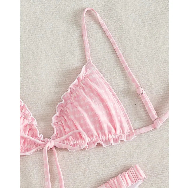 Overhead view of a pink gingham bikini top with adjustable straps and front tie detail