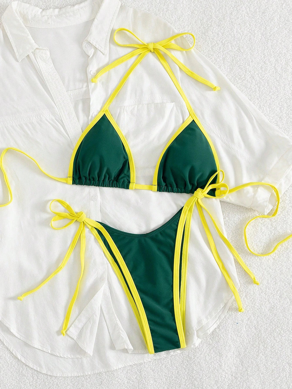 green triangle halter bikini top with yellow contrast trim laid flat with matching green micro thong bottom