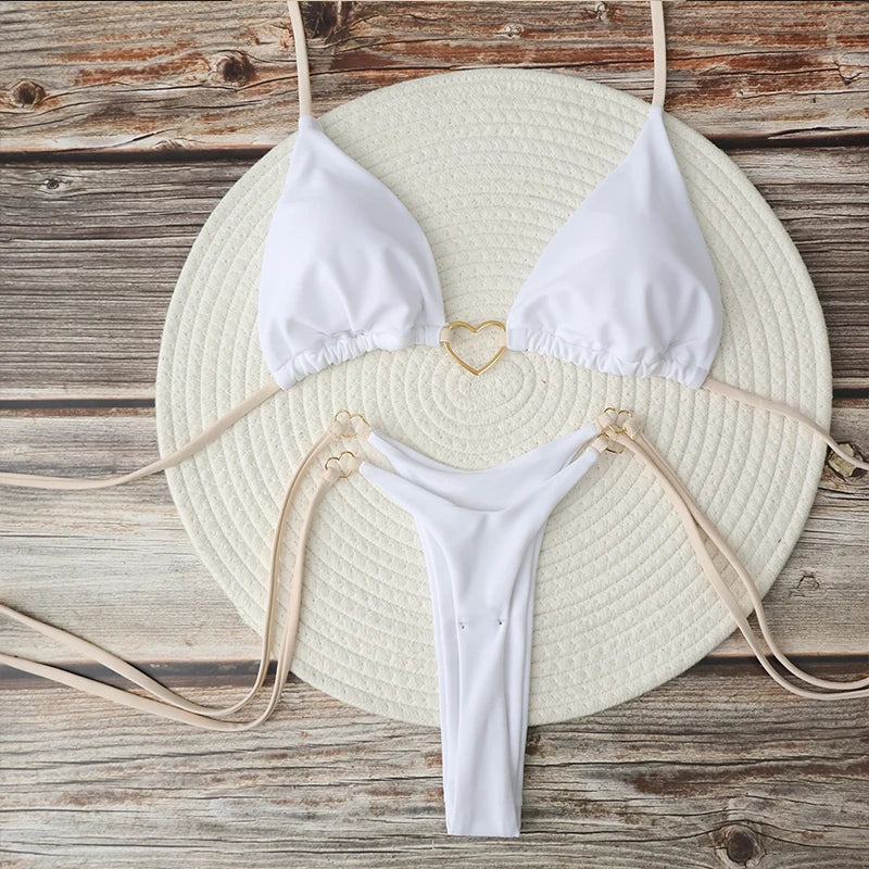 White halter triangle bikini set with gold heart clasp, flat lay