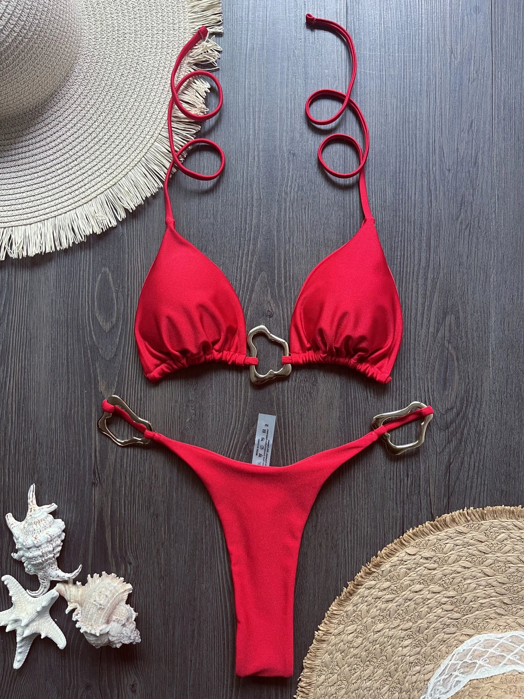 Red halter micro bikini with ring front clasp and thong bottom, flat lay