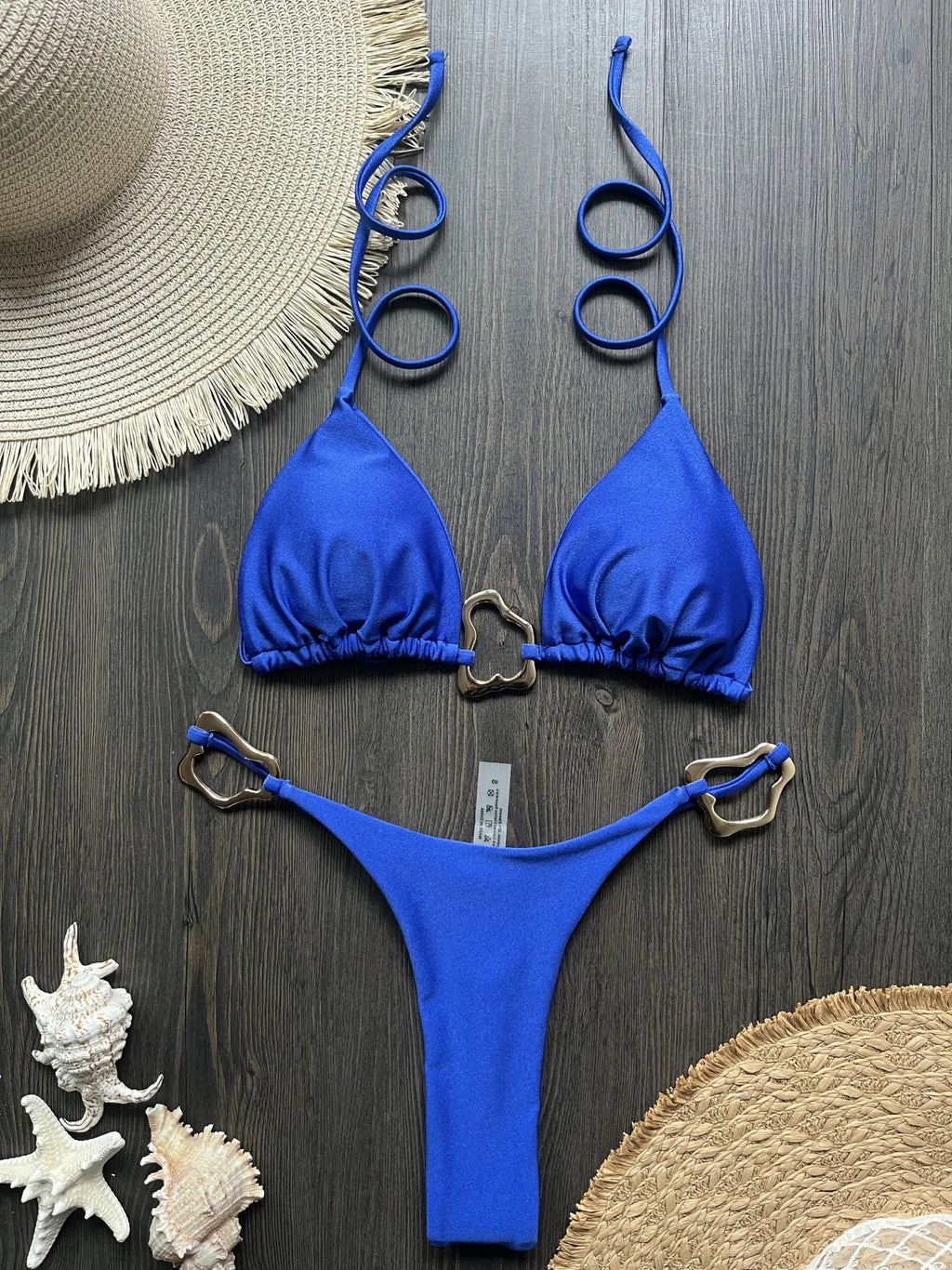 Blue halter micro bikini with ring clasp and thong bottom, flat lay