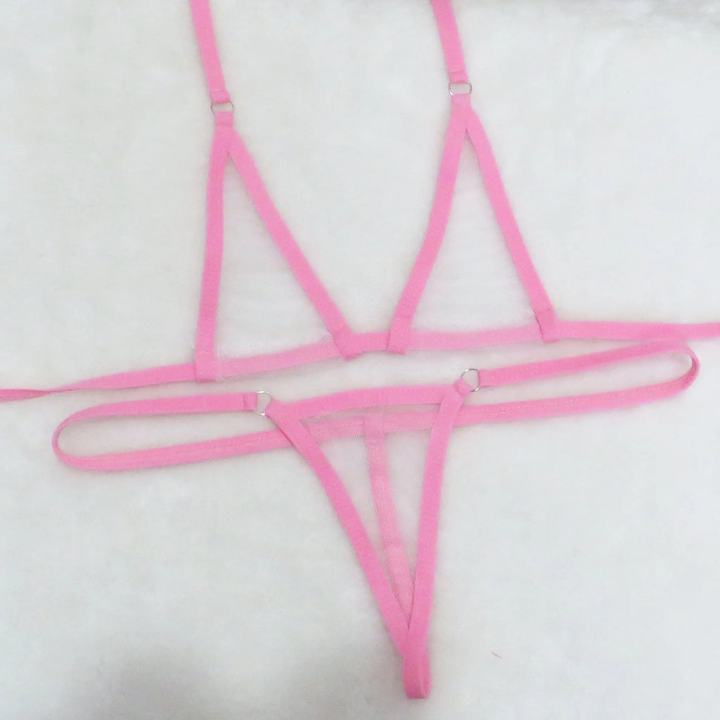 Pink sheer mesh micro bikini set with tie straps and silver O-ring details on white towel