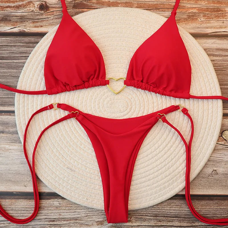 Red halter triangle bikini set with gold heart clasp, flat lay