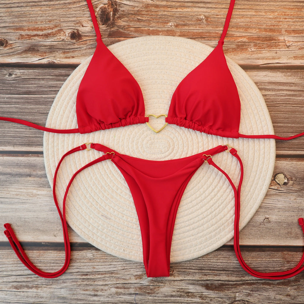 Red halter thong bikini set with gold heart clasp, flat lay
