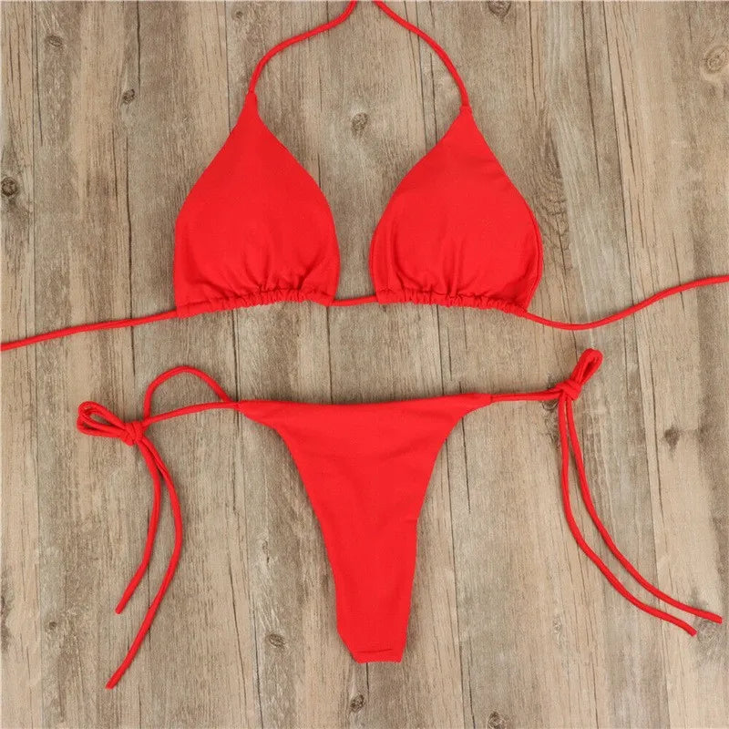 red push up triangle bikini top and thong bottom laid flat on wood