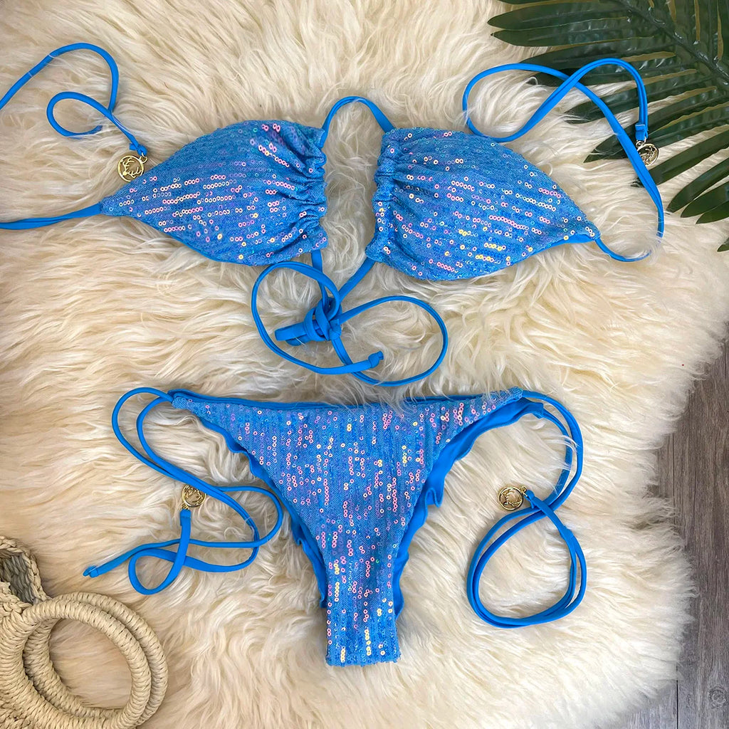 Blue sequin triangle bikini set with ruffle thong bottom on white fur rug with palm leaf