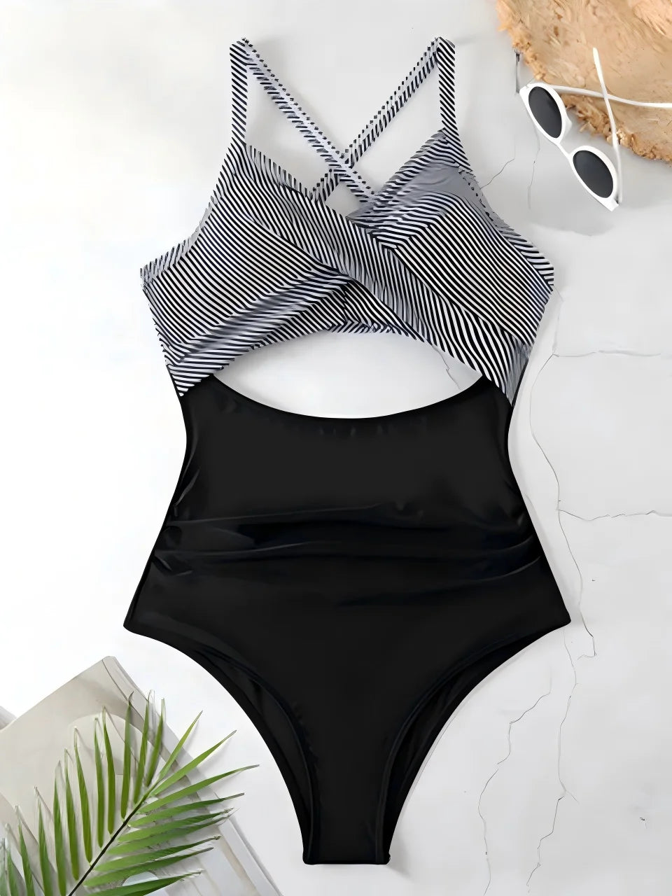black striped cross strap top with black body one piece swimsuit laid flat