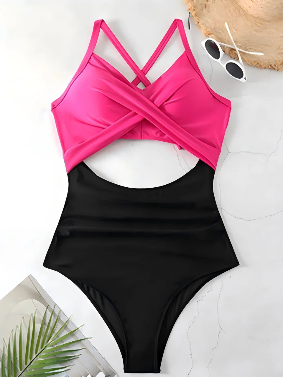 hot pink cross strap top with black body ruched one piece swimsuit laid flat