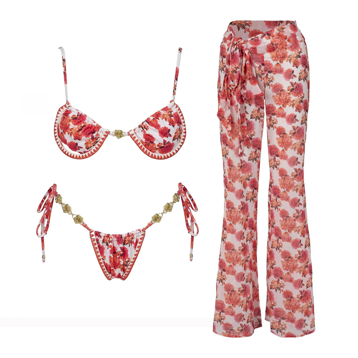 Strappy red floral micro bikini with hanging tie straps and wide-leg floral pants flat lay