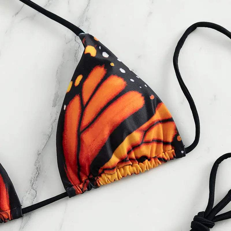 Bañador de bikini triangular con microtanga y cintura baja con mariposas