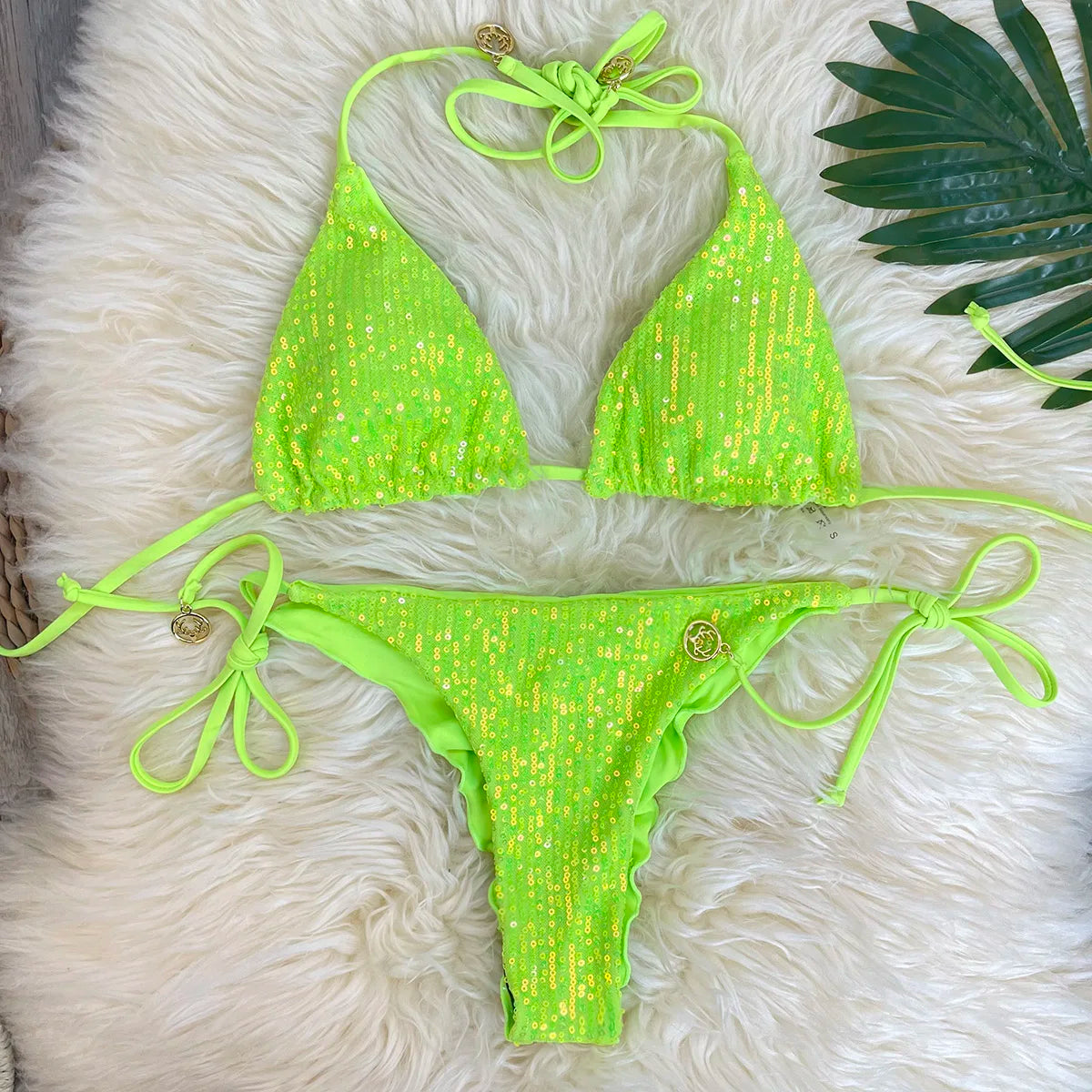 Neon green sequin triangle bikini set with sequin ruffle thong on white fur with palm leaf