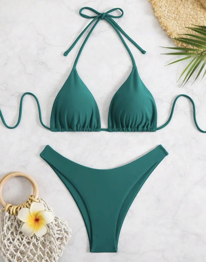 Peacock green ruffle halter bikini set with neck tie and high cut thong bottom on white marble
