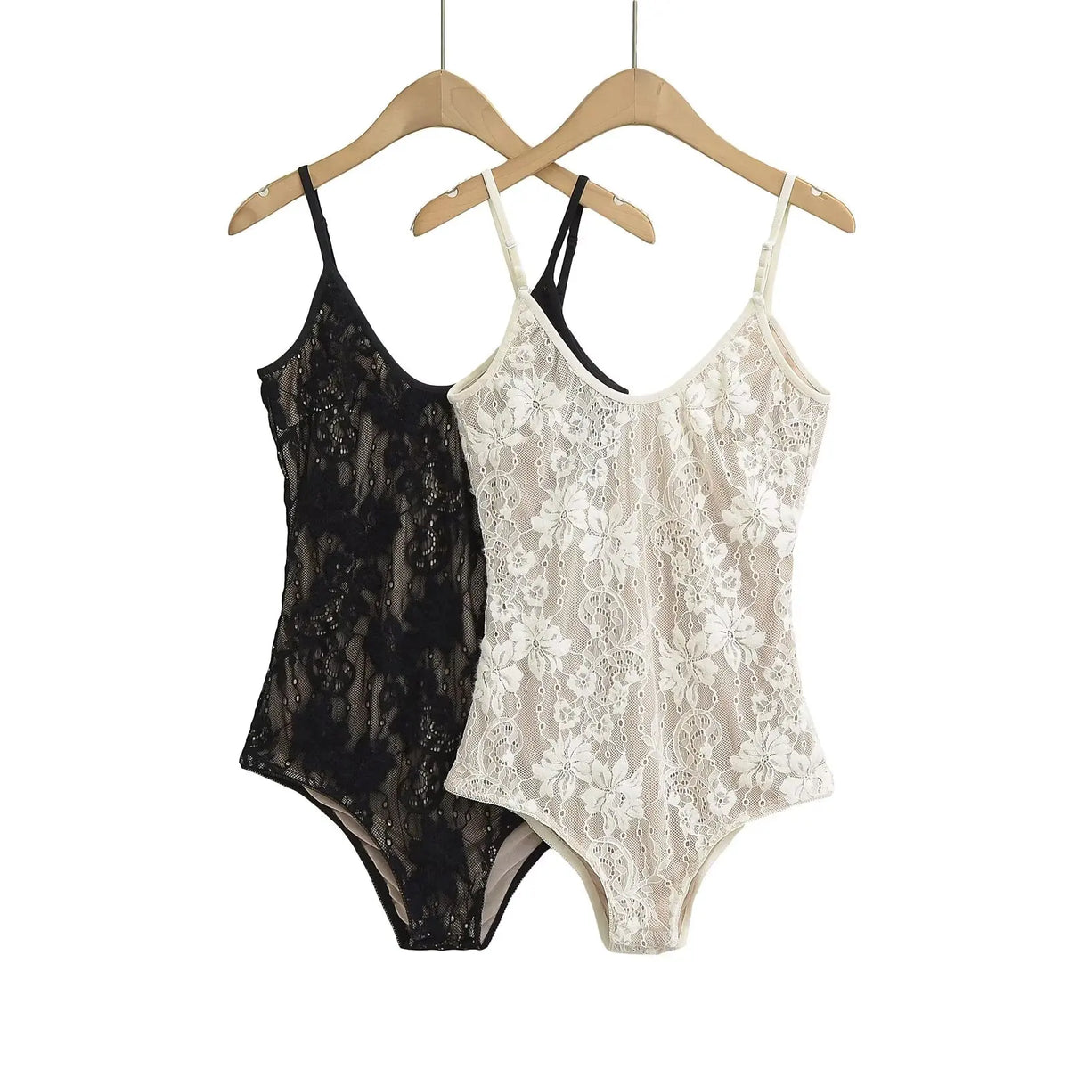Black and white floral lace bodysuits hanging side by side on wooden hangers