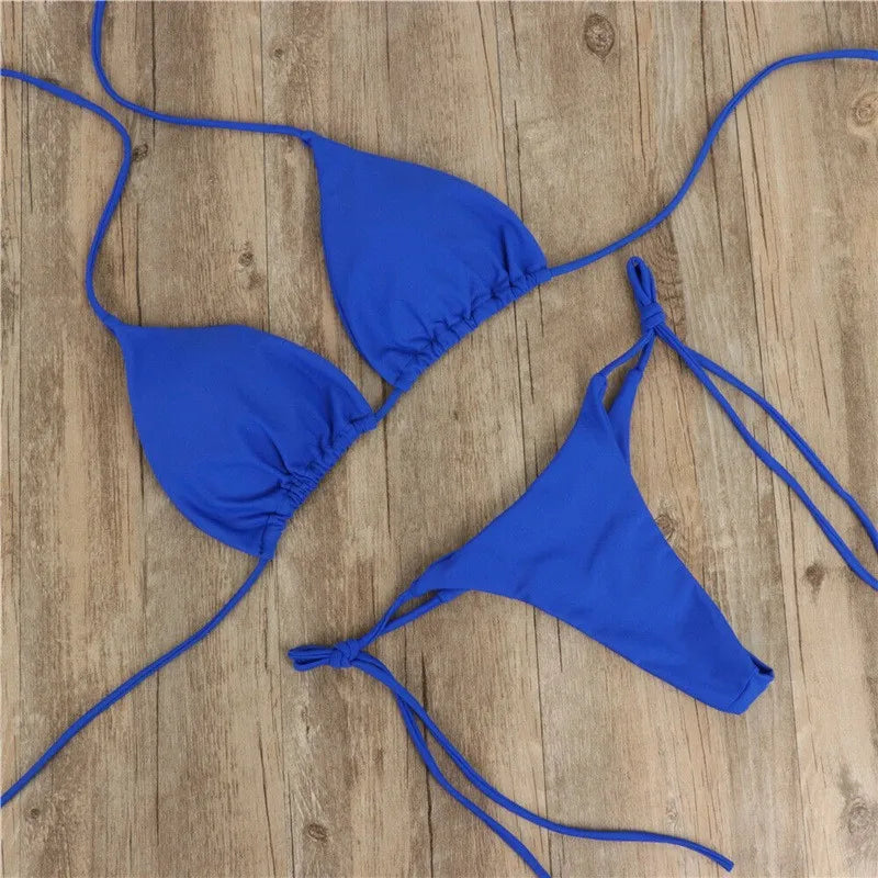 blue push up triangle bikini set with thong bottom laid flat on wood floor