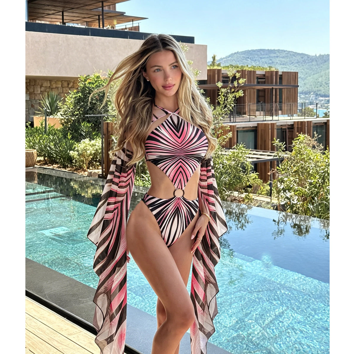 Model in a pink black and white print monokini swimsuit with a matching sheer cover up