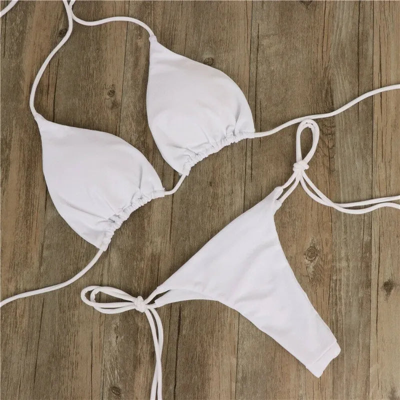 white push up triangle bikini top and thong bottom laid flat on wood