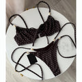 Brown polka dot string bikini with ruffle top, beaded straps, and tie thong bottom laid on a white marble table