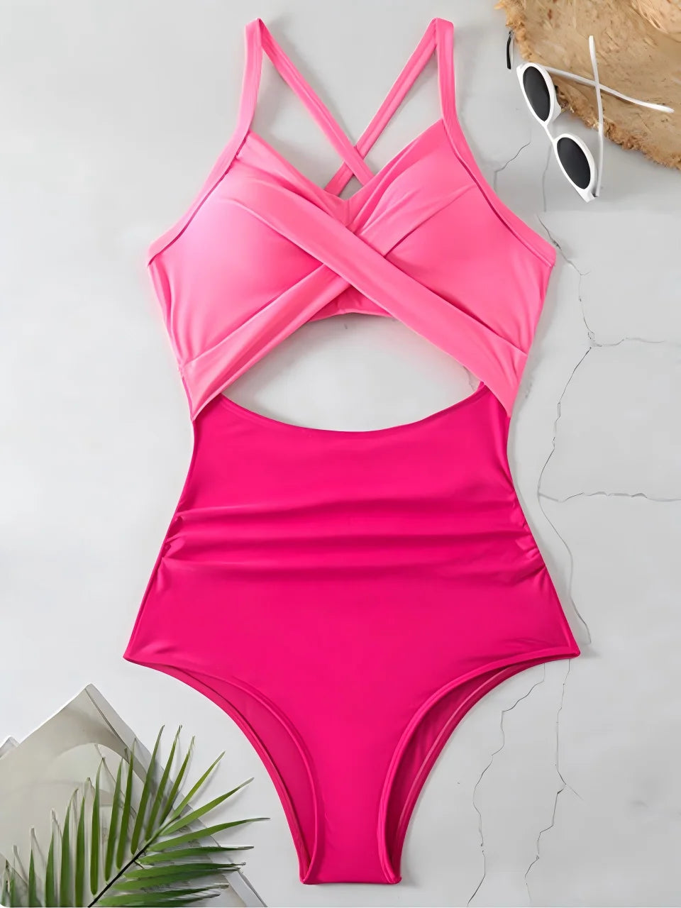 pink cross strap top with hot pink body ruched one piece swimsuit laid flat