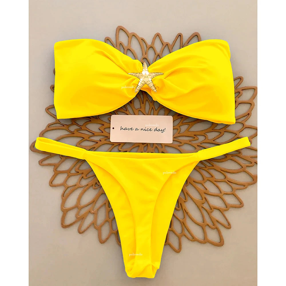 Yellow knot bandeau bikini set with gold starfish and micro thong bottom, flat lay