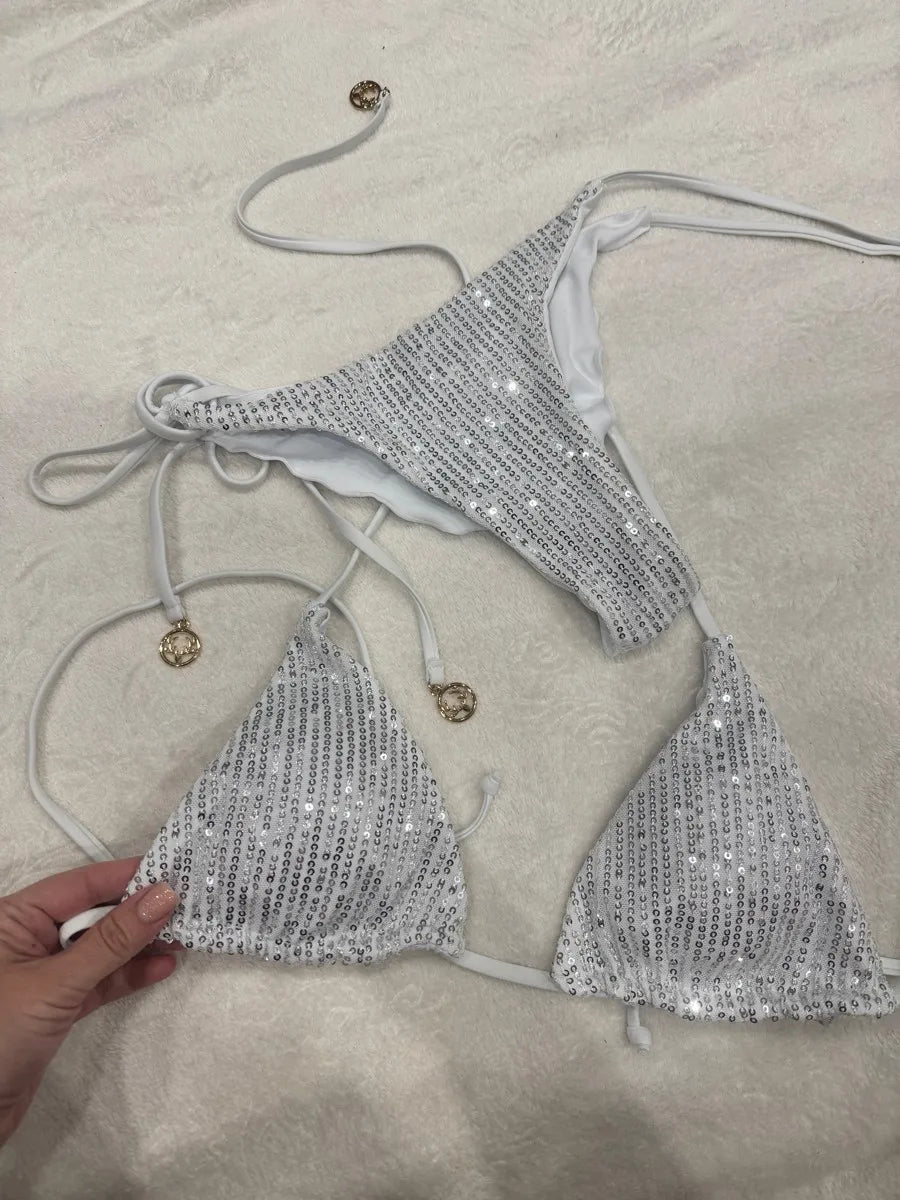 Silver white sequin bikini set with tie straps and gold disc charms on cream towel