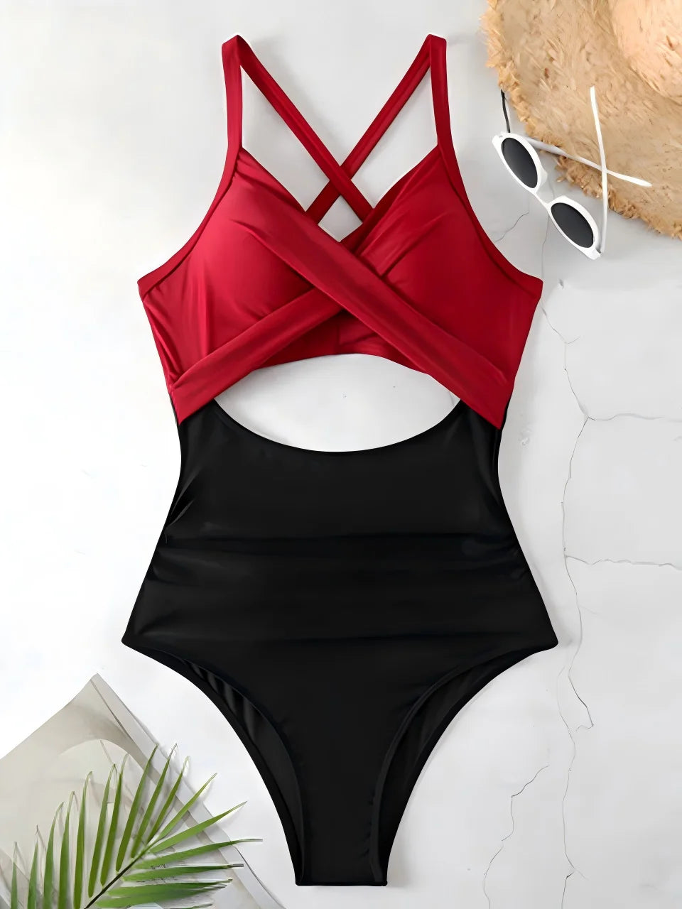 red cross strap top with black body ruched one piece swimsuit laid flat