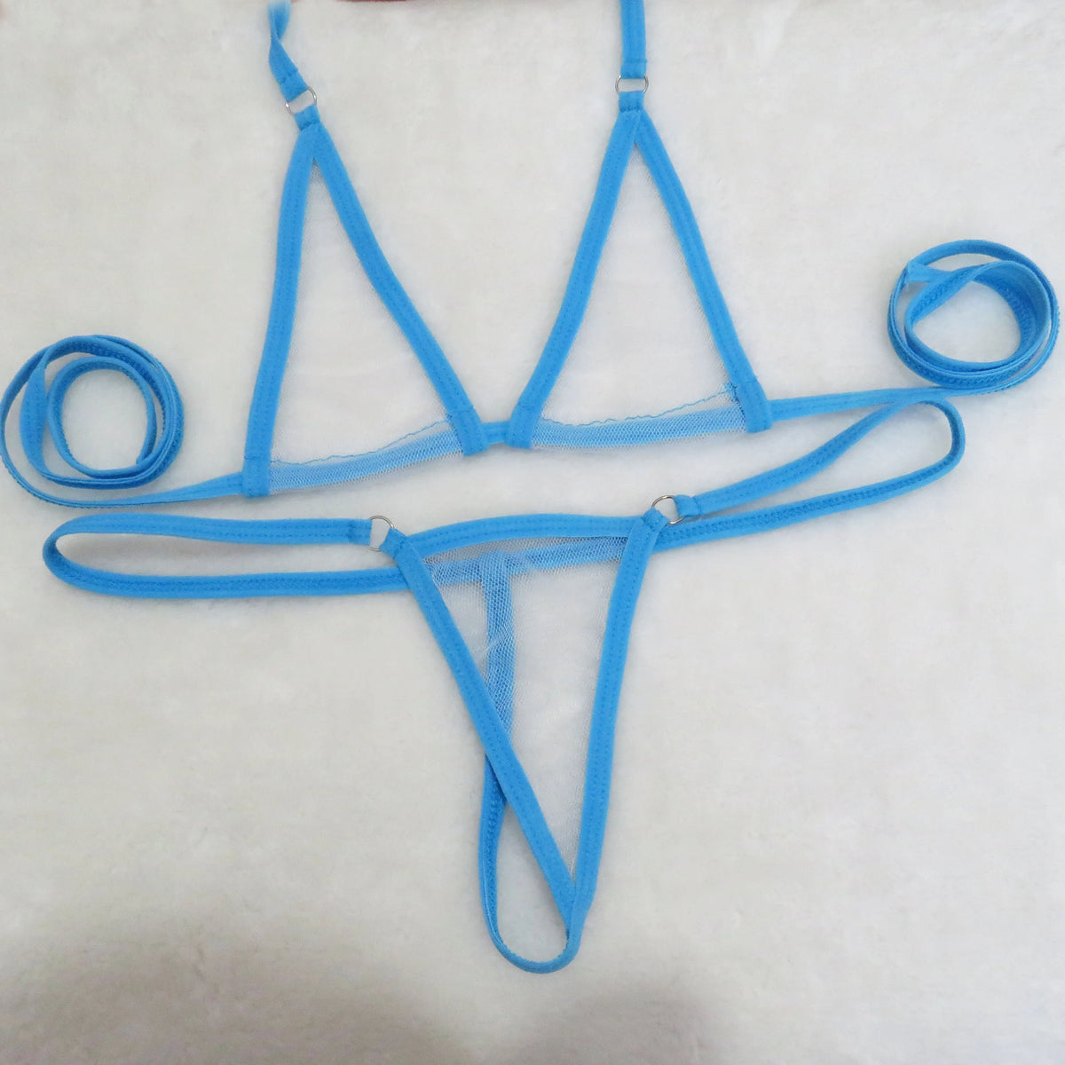 Sky blue sheer mesh triangle top and string thong bottom with tie straps on white towel