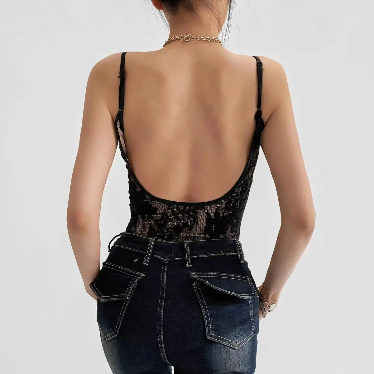 Back view of black floral lace bodysuit showing open backless fit and thin straps