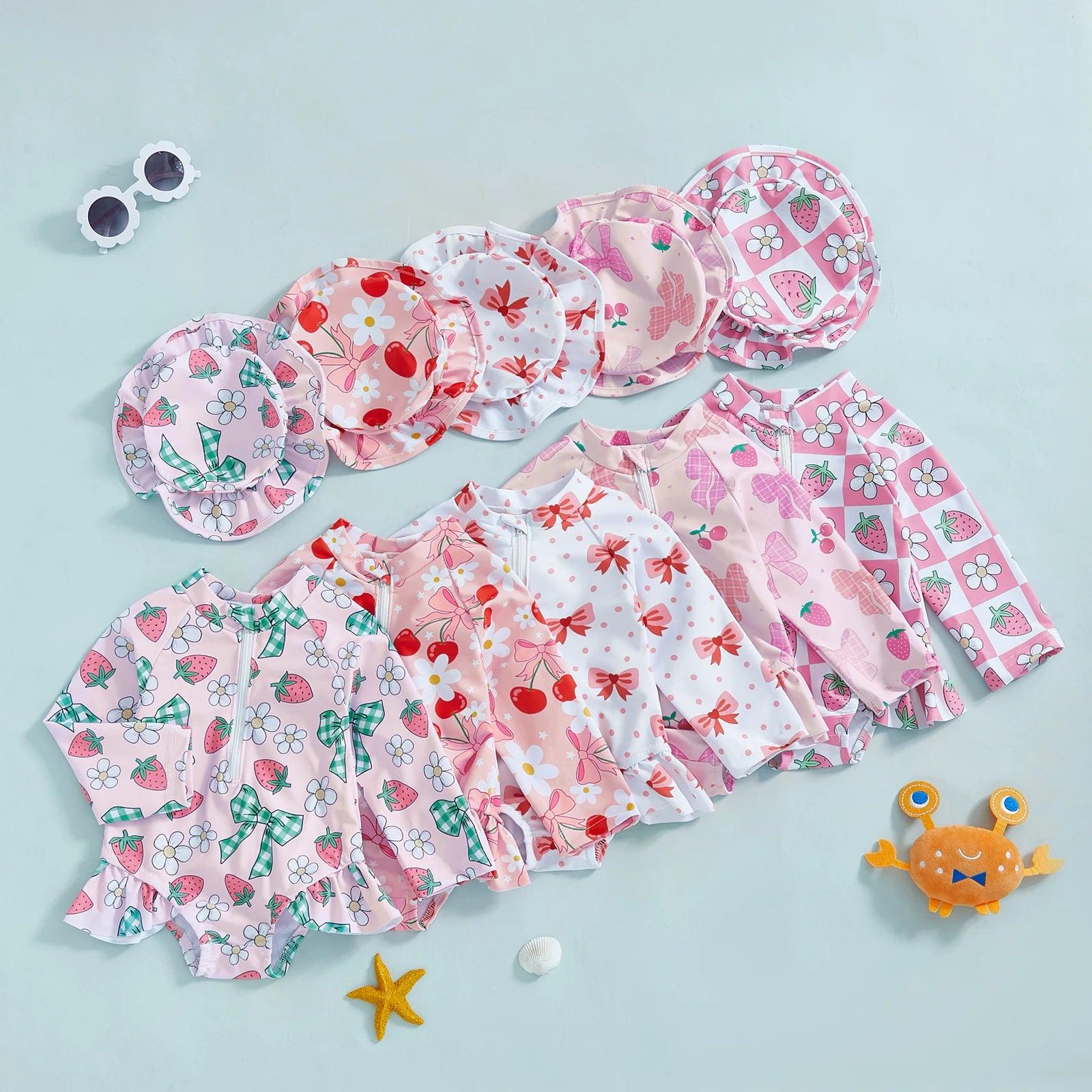 Toddler girls long sleeve rash guard swimsuit in pink and white with ruffled sleeves bows and floral strawberry patterns