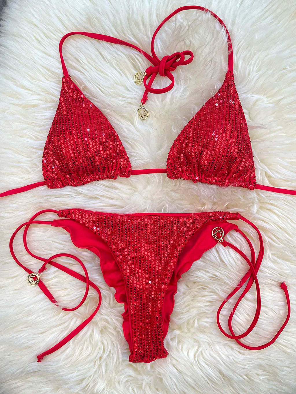 Red sequin triangle bikini top and sequin ruffle thong bottom with tie straps on white fur