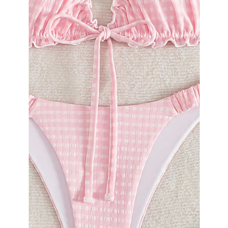 Close-up of a pink gingham bikini top with ruffled trim and a center front tie