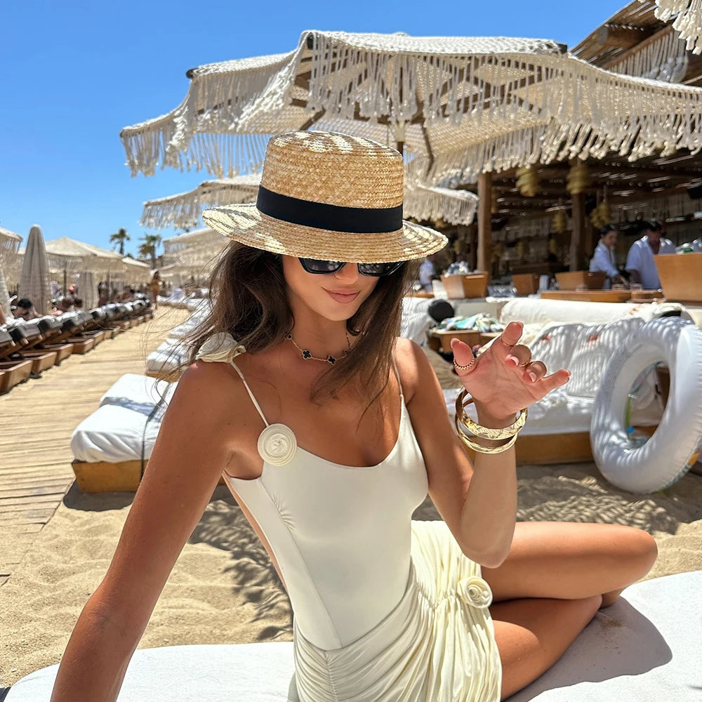 woman in ivory ruched mini dress swimsuit with straw hat on the beach