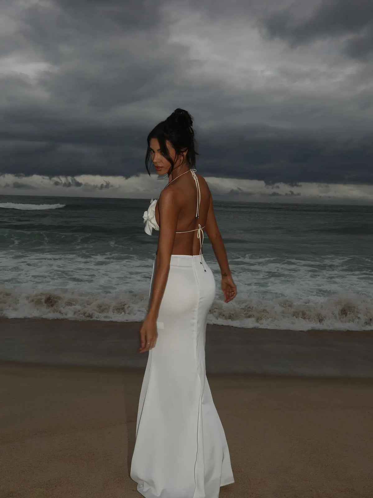 Back view of the white floral applique bikini worn with a smooth solid white maxi skirt