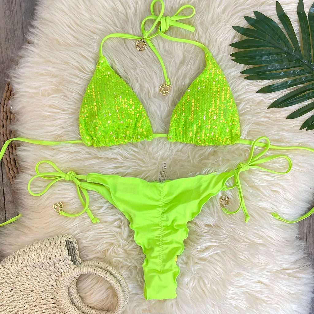 Neon green sequin triangle top with solid ruffle thong bottom on white fur with palm leaf