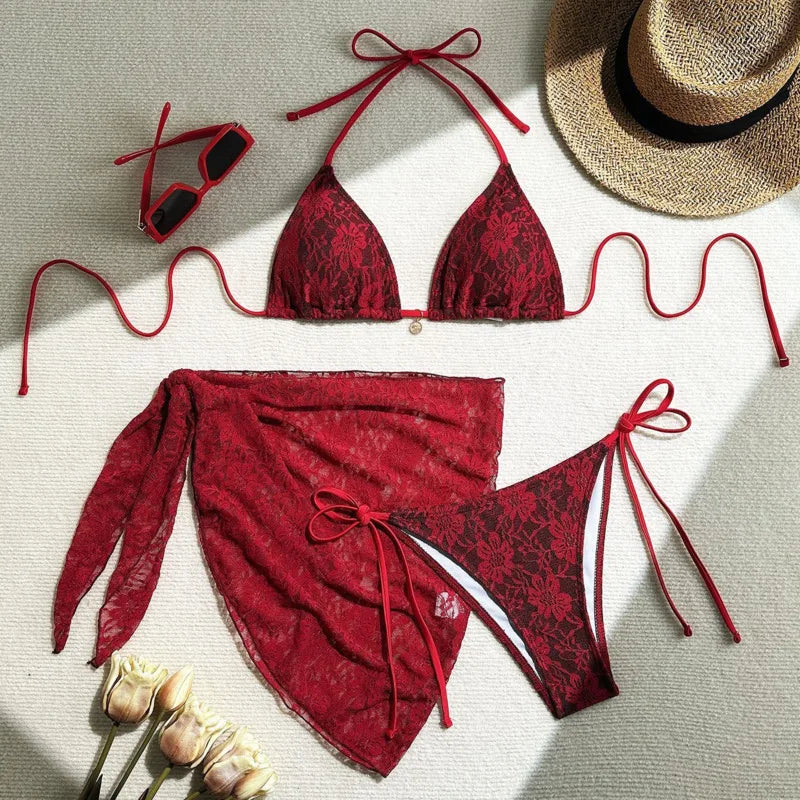red lace bikini set laid flat with sheer cover up on linen