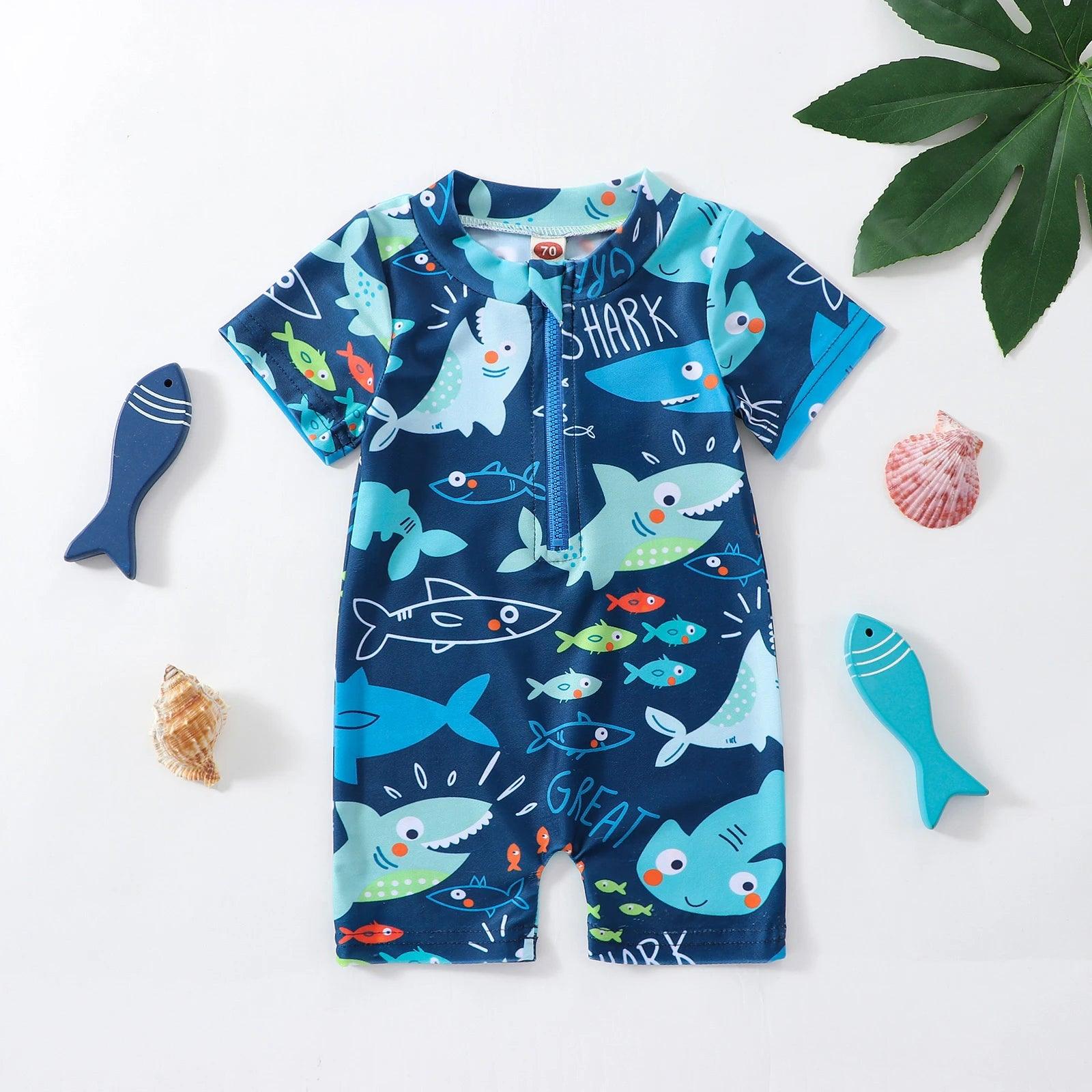 Navy blue toddler boys short-sleeve swim onesie with zipper and playful shark and fish pattern in teal light blue and orange