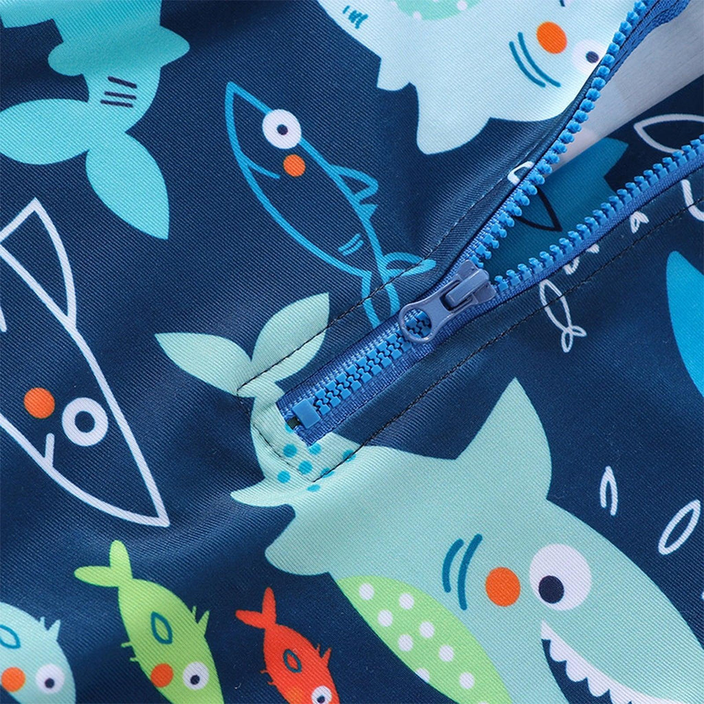 Blue toddler boys zippered swim trunks with playful shark and fish pattern on dark navy fabric for swimming