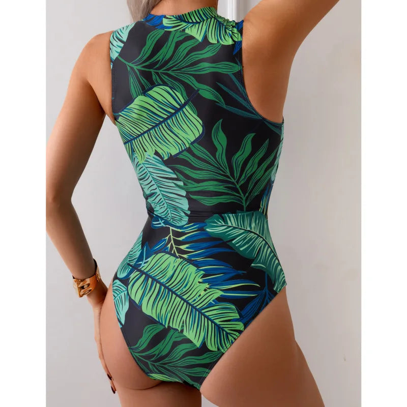 Tropical patchwork one-piece swimsuit with front zipper featuring green and blue leaf pattern and black side panels3