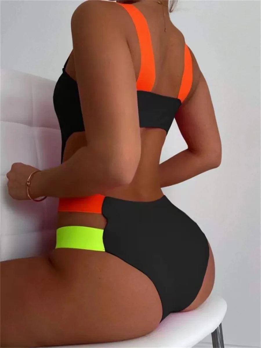 Black one-piece swimsuit with neon orange straps and a high-waisted bottom featuring a bright green waistband