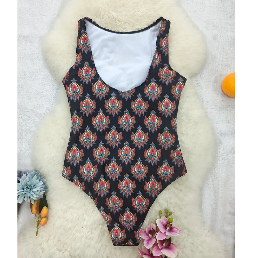 Black one-piece swimsuit with vibrant ethnic floral animal paisley pattern in red orange and teal shades