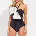 Black one-piece swimsuit with white bow cut-out at bust and halter straps